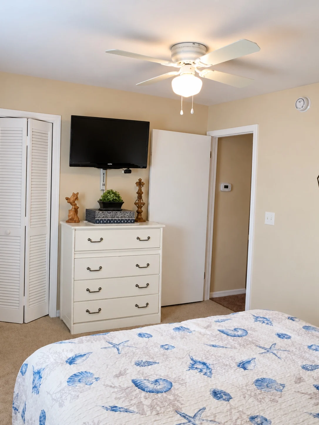 Alternate view of the blue coastal bedroom showing dresser, television and closet