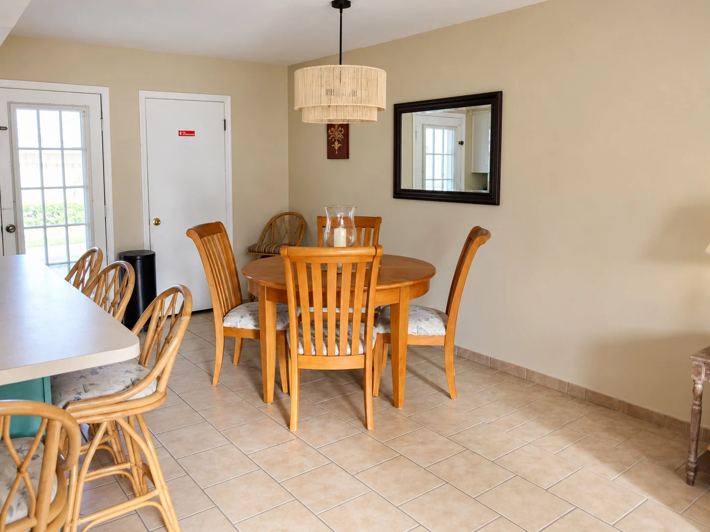 Current dining area at Baker's Tide with round table and woven coastal light fixture