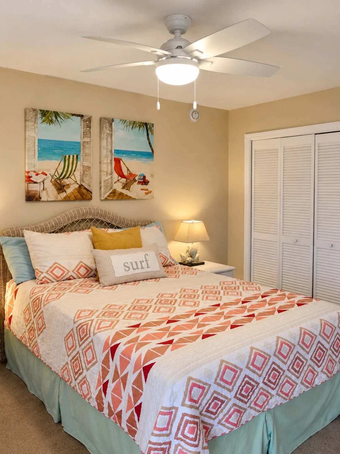 Coral coastal bedroom at Baker's Tide with beach artwork and wicker headboard
