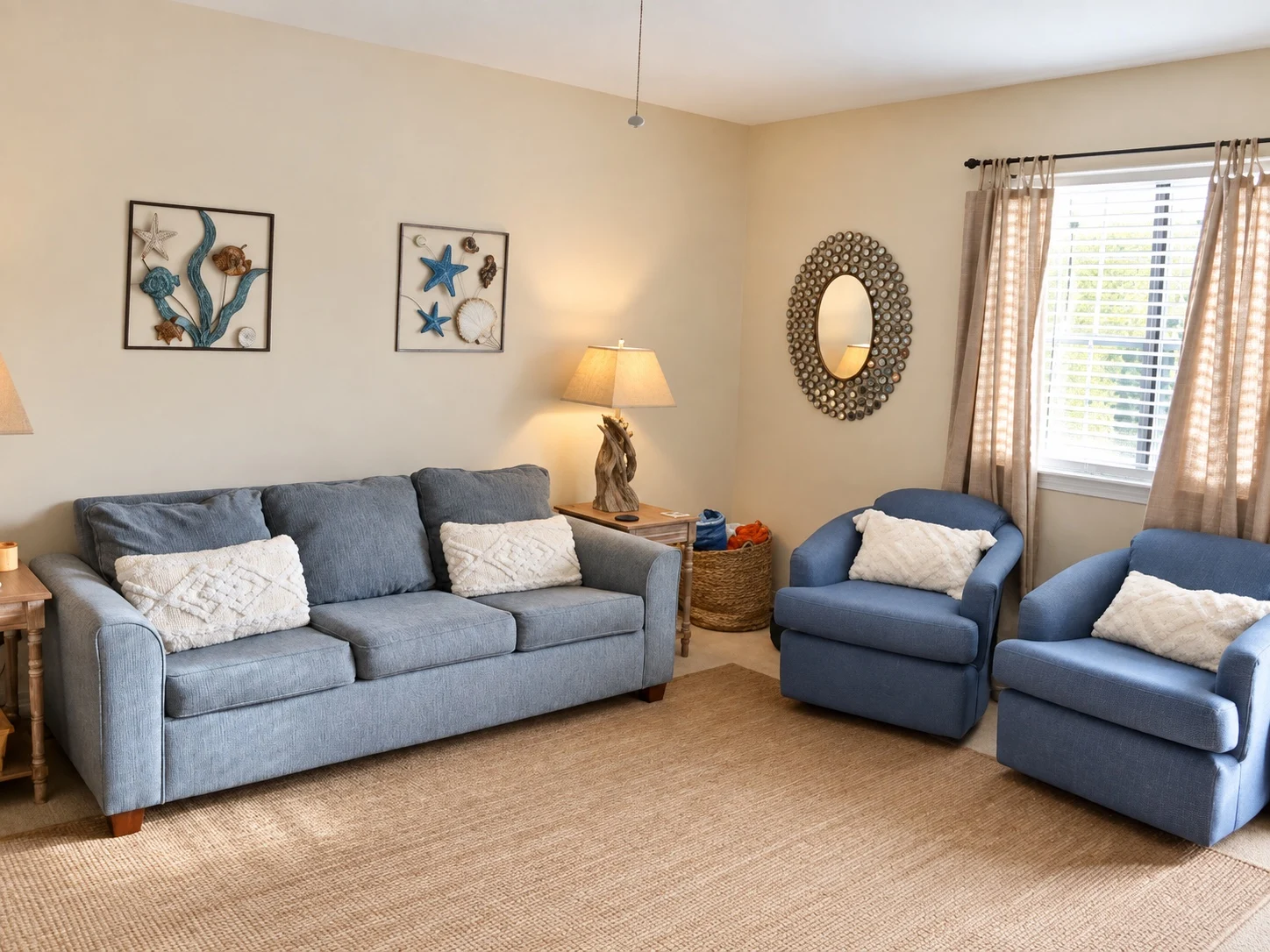 Current living room at Baker's Tide with blue sofa, matching chairs and coastal decor