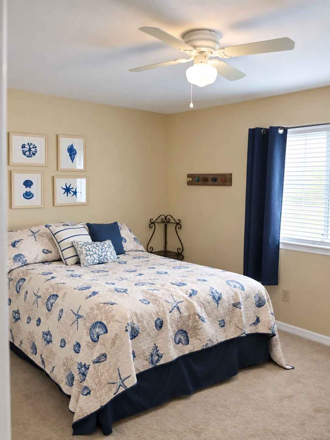 Blue coastal bedroom at Baker's Tide with seashell bedding and navy accents
